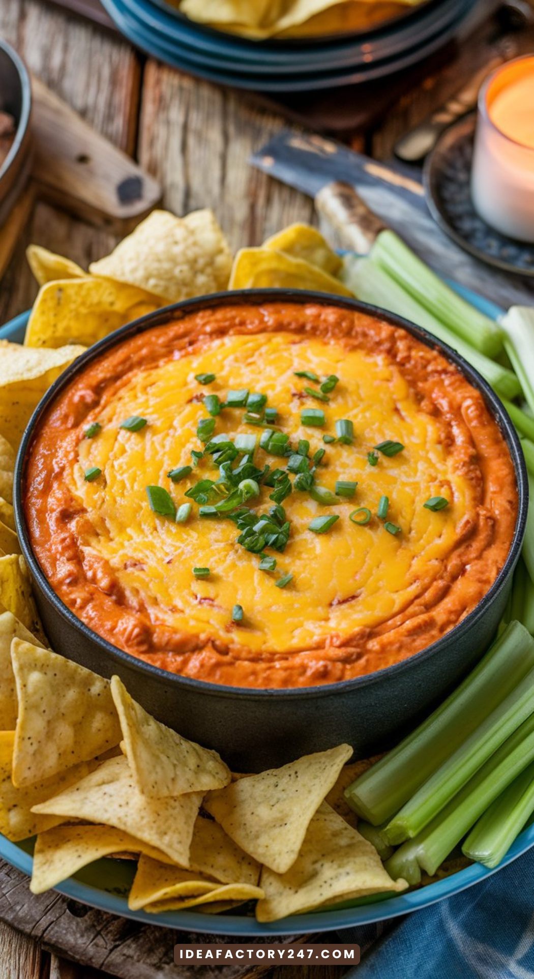 Easy buffalo chicken dip recipe served on a rustic wood table with chips and veggies.