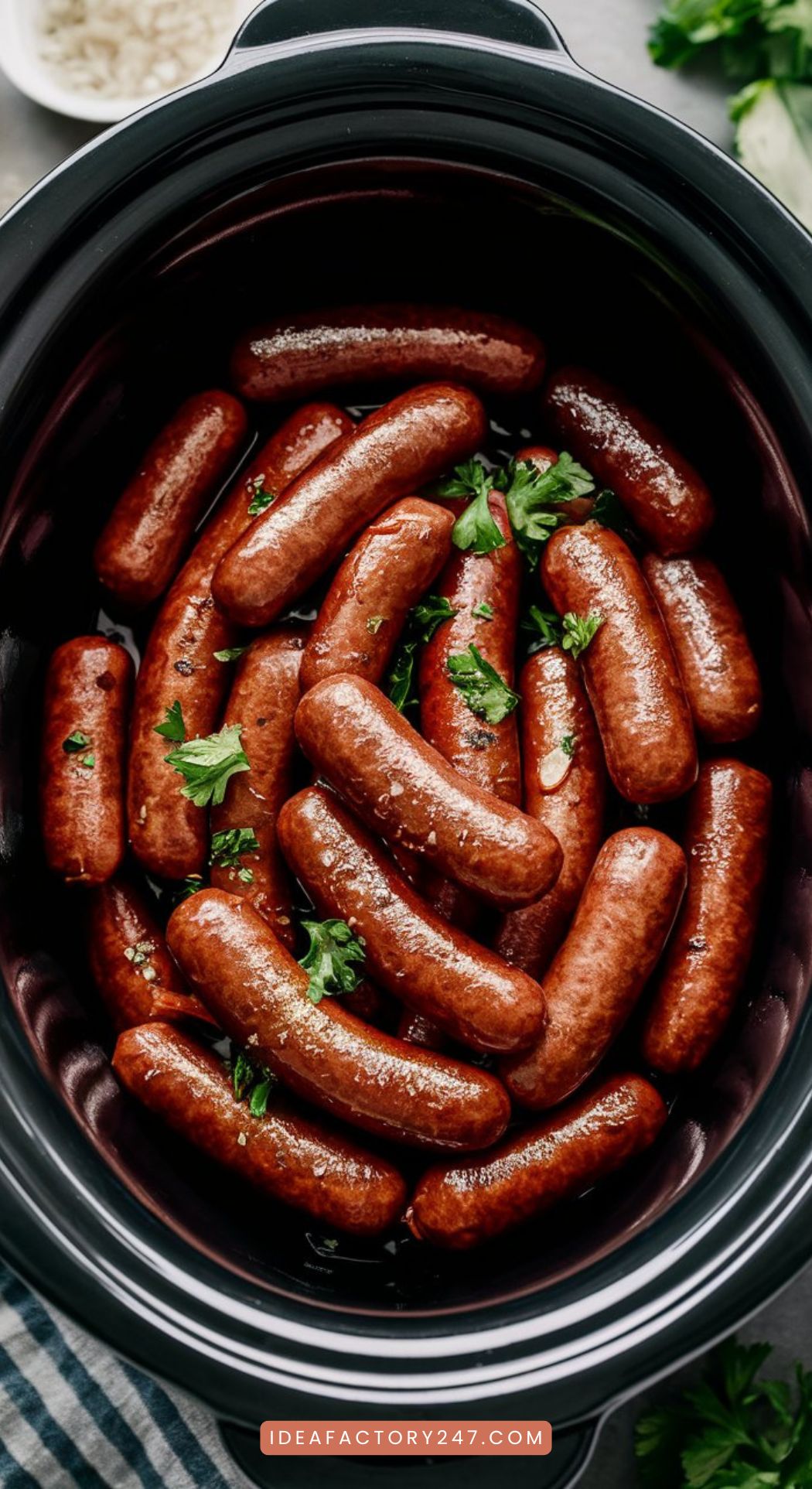 A crockpot filled with glistening honey garlic sausages, garnished with chopped parsley, and served with toothpicks.