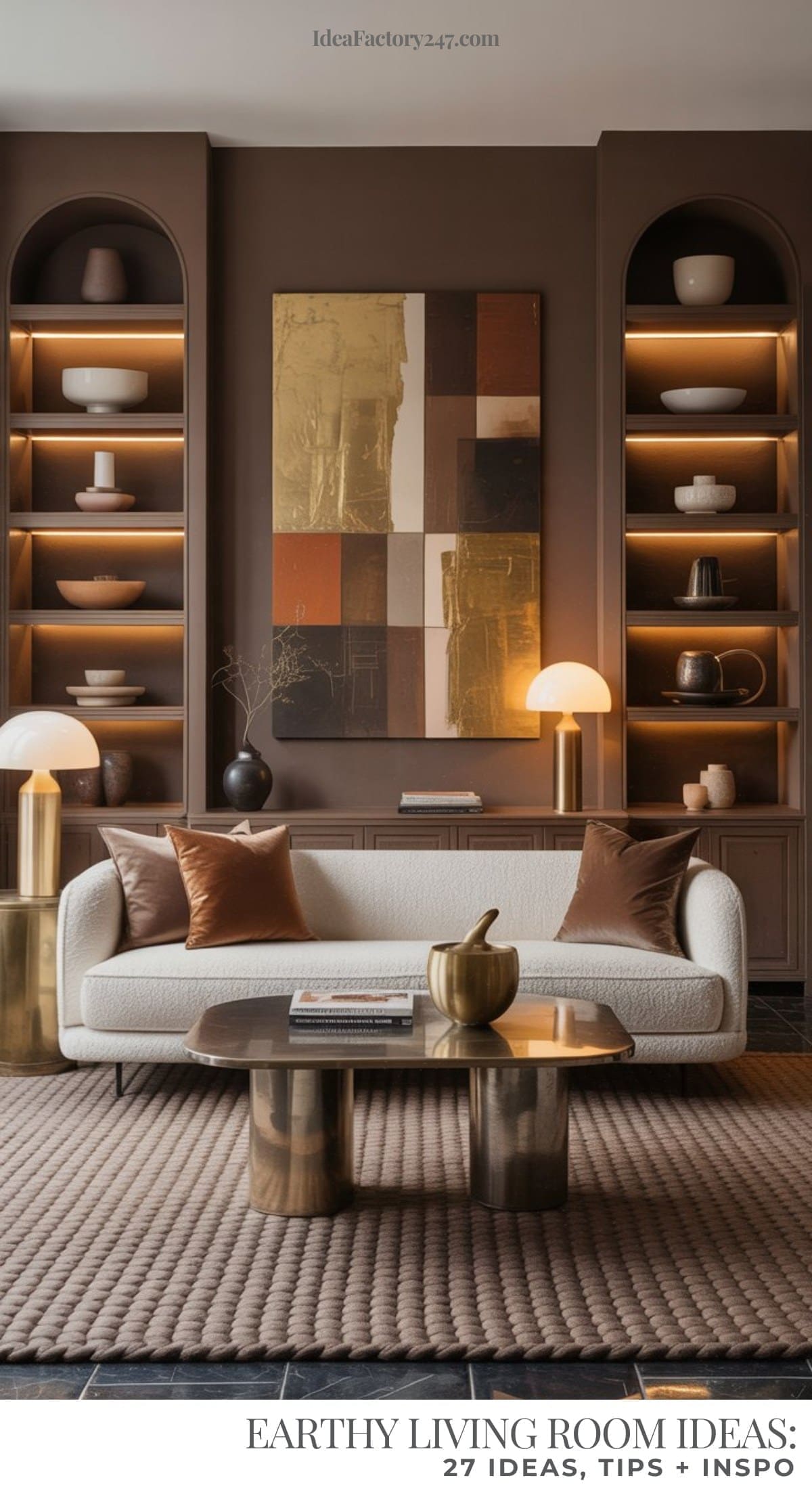 A modern living area with white sofa, bronze and gold accents, a textured rug, built-in shelves with decor, and abstract wall art. The space is warm and inviting with soft lighting and natural tones throughout.