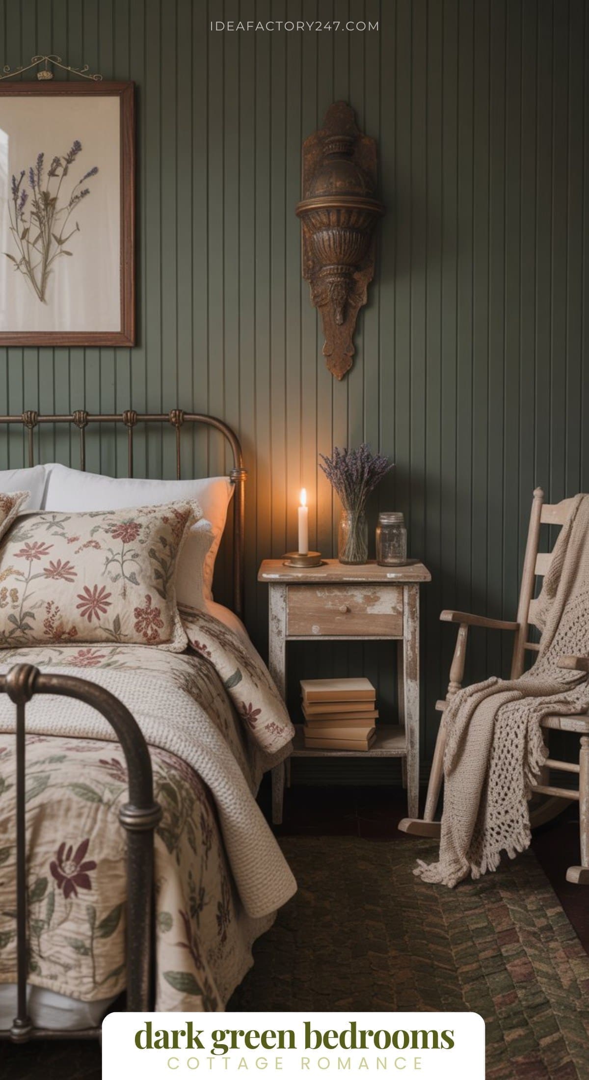 Love moody dark green home decor? We do too! This is part of our Dark + Moody Green Bedroom Collection. (click to see all the inspo!)A cozy bedroom with dark green paneled walls, a metal bed with floral bedding, a wooden chair, a rustic nightstand with a lit candle, stacked books, a vase of lavender, and wall art featuring pressed flowers.