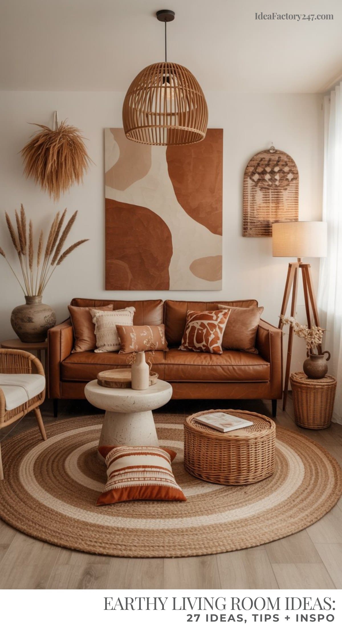 An earthy living room with cozy vibes features a brown leather sofa, round woven rug, rattan light fixture, abstract wall art, wicker furniture, pampas grass decor, and neutral accent pillows.