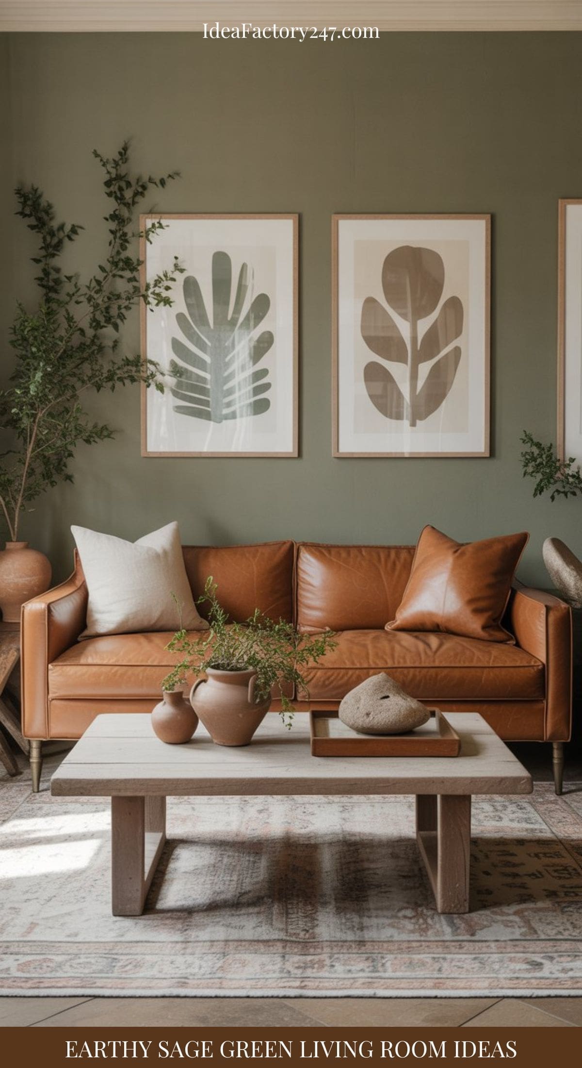 A cozy sage green living room featuring a brown leather sofa, wooden coffee table, potted plants, clay vases, and three botanical prints in wooden frames. Earthy, natural decor enhances the inviting space.