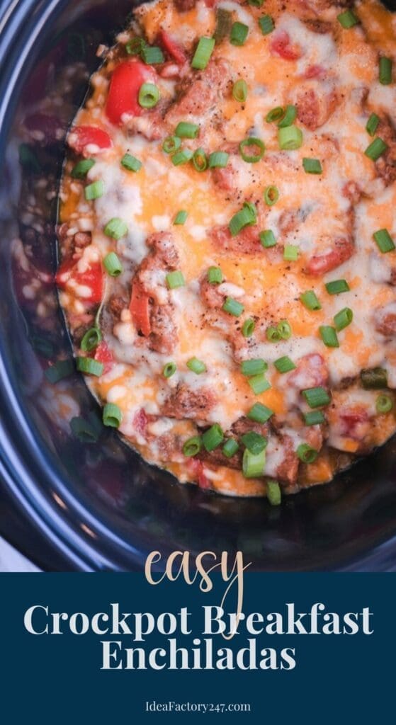 Crockpot filled with cheesy breakfast enchiladas topped with chopped green onions and tomatoes, shown from above. Text overlay reads: Easy Crockpot Breakfast Enchiladas. IdeaFactory247.com.