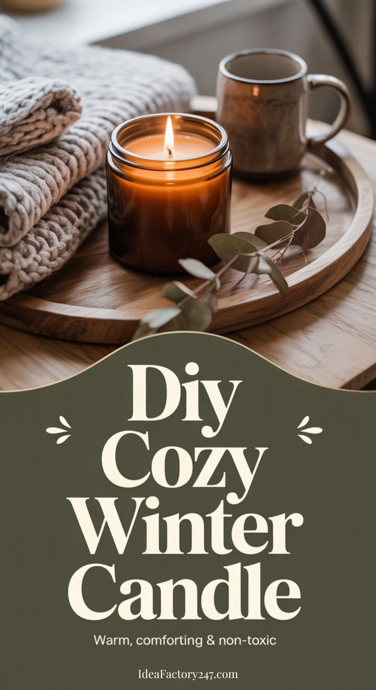 A lit Winter Candle, folded knit blankets, a cup, and eucalyptus are arranged on a wooden tray. Text below reads: DIY Cozy Winter Candle. Warm, comforting & non-toxic.