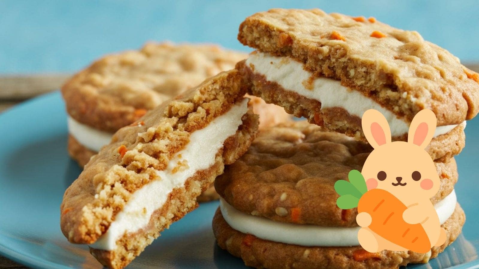A plate of carrot cake cookies filled with creamy frosting, stacked on top of each other. An illustrated bunny holding a carrot is overlaid in the bottom right corner.