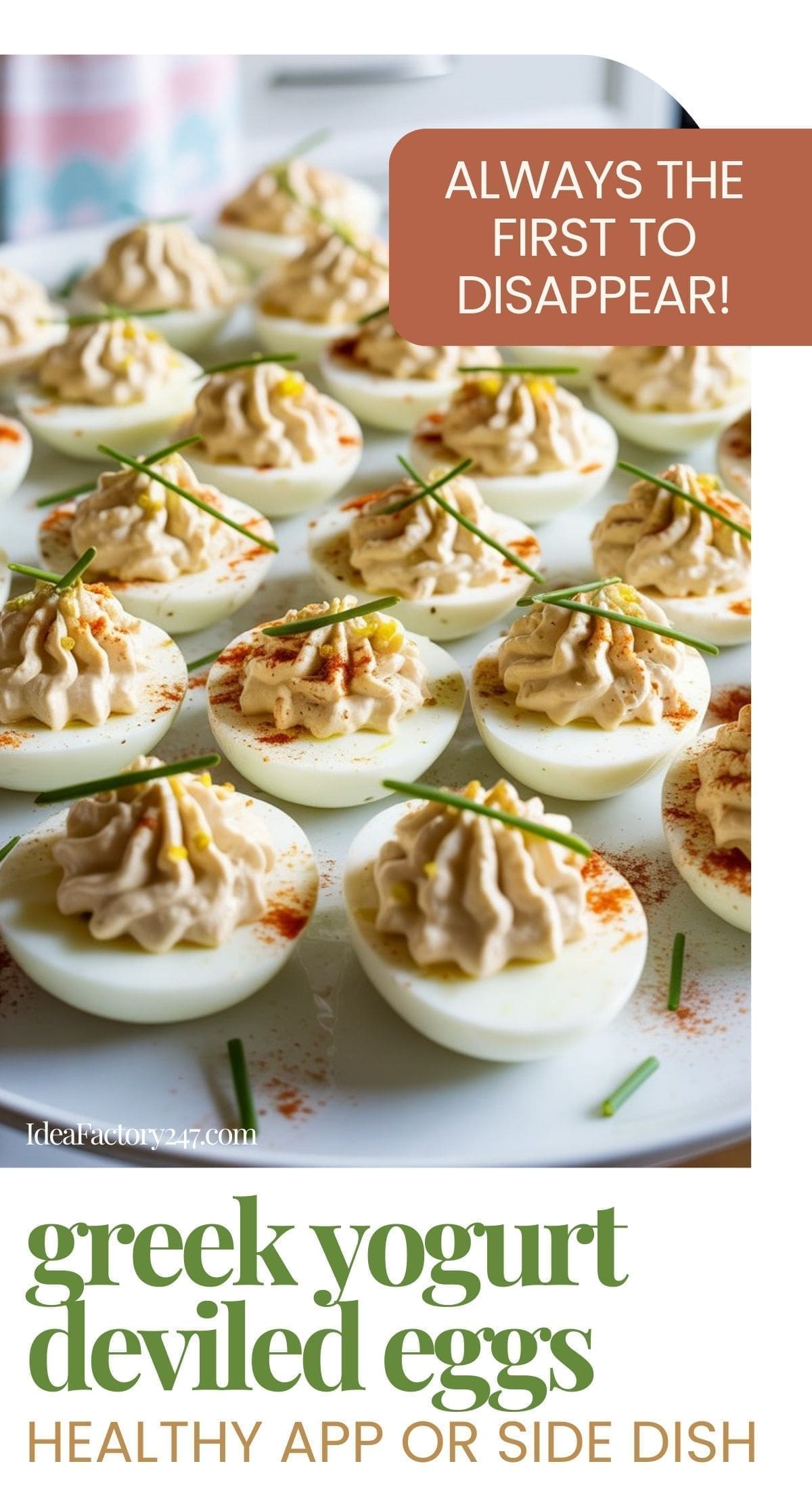 A platter of Greek yogurt deviled eggs garnished with chives and paprika sits on a table. Text reads “ALWAYS THE FIRST TO DISAPPEAR!” and “greek yogurt deviled eggs—healthy app or side dish.”.