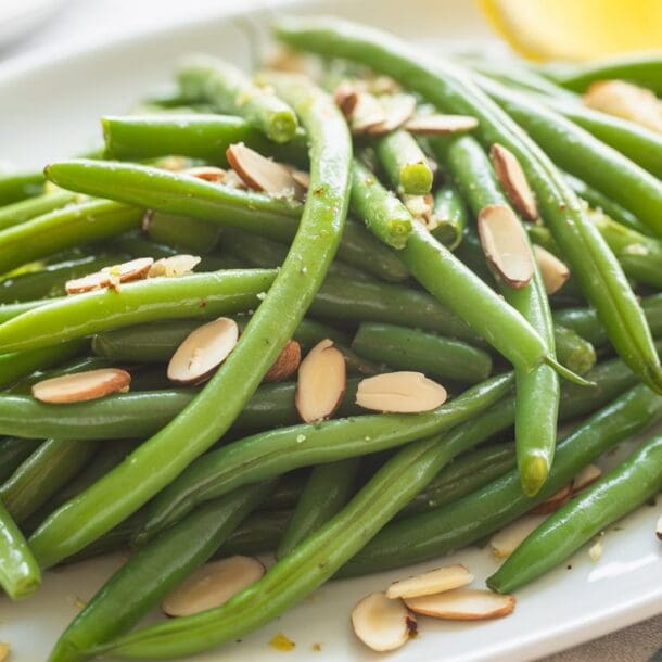 A plate of green beans with almonds, prepared in the classic Green Bean Almondine style.