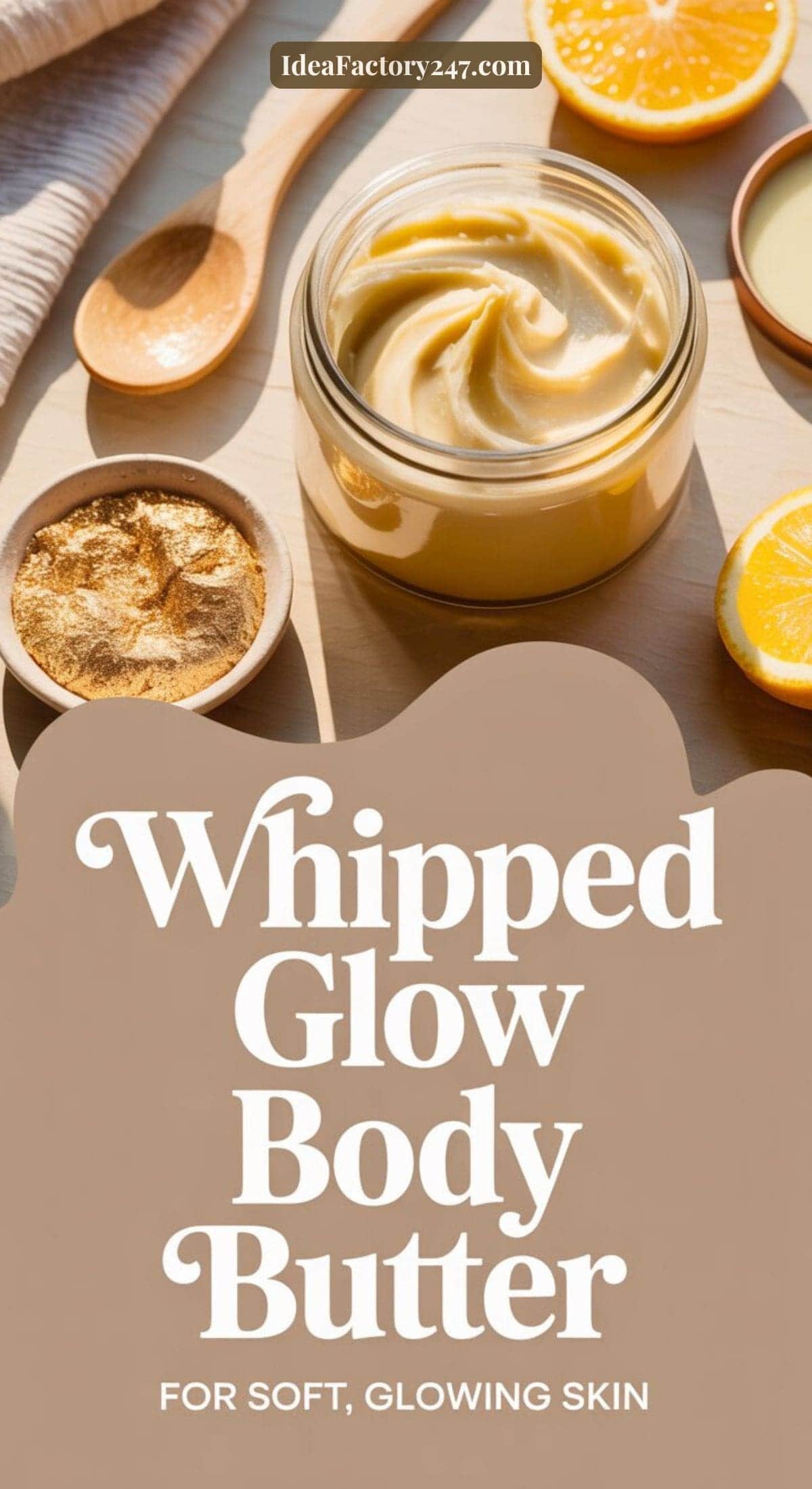 A jar of creamy whipped body butter sits on a wooden table, surrounded by a wooden spoon, powder, and lemon slices. Text overlay reads: Whipped Glow Body Butter for soft, glowing skin.