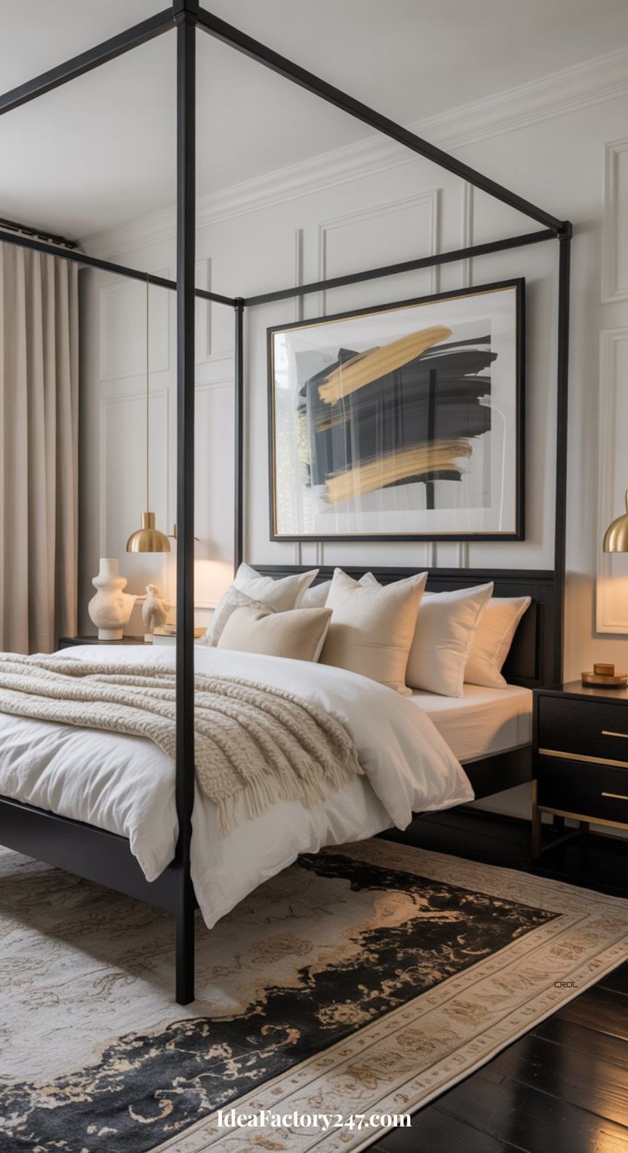 A modern bedroom with a black four-poster bed, white bedding, neutral throw blanket, abstract artwork above the bed, gold-accented lamps, black nightstands, and a patterned rug on dark wood floors.