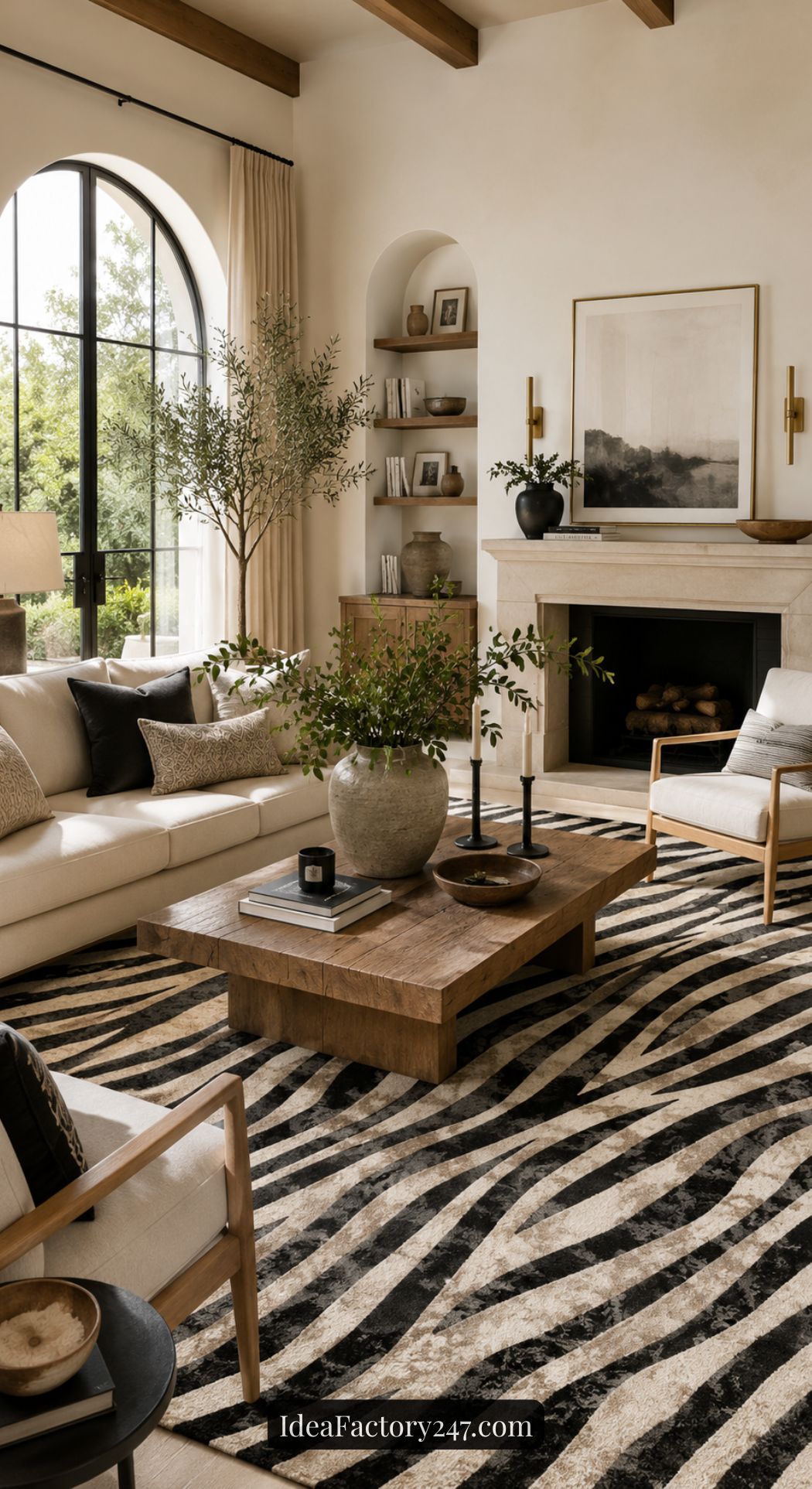 A modern living room with neutral tones, a large zebra-patterned rug, a wooden coffee table with vases, a white sofa, armchairs, a fireplace, wall art, and large arched window with curtains and greenery outside.
