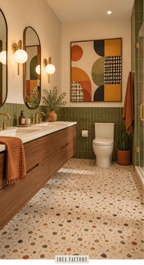A bathroom with a long wooden double vanity, green wall tiles, terrazzo-style flooring, and a large abstract art print on the wall.